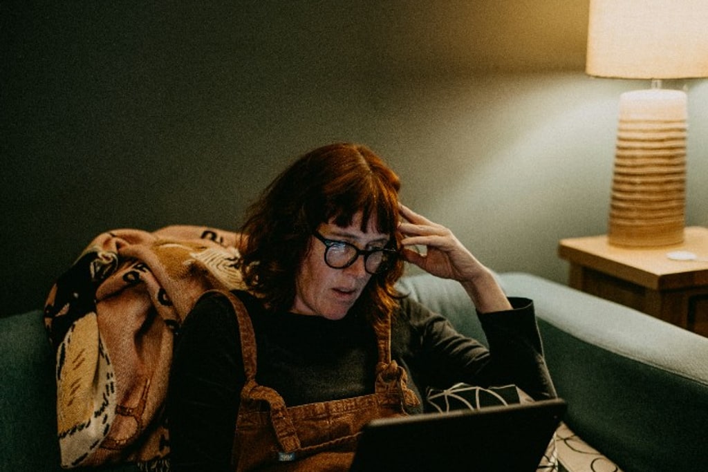 Person arbeitet auf einem Sofa mit einem Laptop